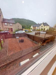 een achtertuin met een tuin met grind en een hek bij 1 Carn Dearg in Fort William +6 foto's