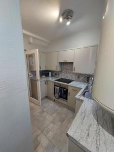 een keuken met witte kasten en een kookplaat oven bij 1 Carn Dearg in Fort William