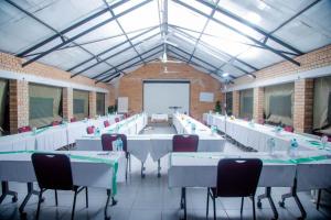 une grande salle avec des tables et des chaises et un écran de projection dans l'établissement Executive comfort with premium workspace - 2334, à Kwekwe 6 autres photos