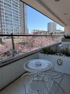 a balcony with a table and chairs and a window at Apart Hotel Uman in Concepción