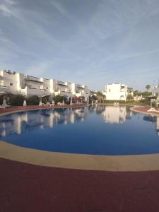 a large swimming pool in front of some buildings at Super villa de haut standing in Dar Merah Deriba