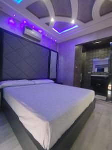 a bedroom with a large bed with purple lighting at Super villa de haut standing in Dar Merah Deriba