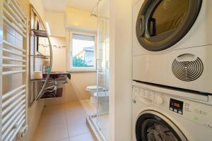un lavadero con lavadora y secadora en Modern Apartment 5 Minutes from Rho, en Lainate