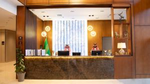 Zwei Personen sitzen an einem Empfangstresen in der Hotellobby in der Unterkunft Grand hotel alhamra in Dschidda + 47 Fotos