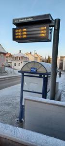 a bus stop with a sign on a street at Central apartment with 2 bedrooms in Tromsø