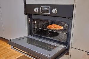 a pizza is cooking in an oven at SEEGER Living Comfort Downtown in Karlsruhe +19 photos