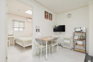 a white room with a table and a bed at Travel Home in Seoul