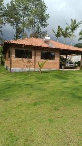 uma casa com um jardim relvado com uma casa em Chacara Sossego em Monte Sião