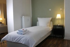 Zimmer im Zentrum mit drei Einzelbetten في بادربورن: غرفة نوم بها سرير مع مناشف عليه