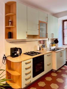 a kitchen with white cabinets and a stove top oven at Residenza Renata in Onno +52 photos