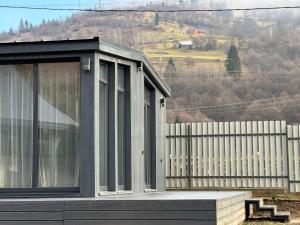 a black house with a fence and a hill at Grey House in Kvasy
