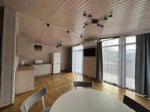 a kitchen and dining room with a white table and chairs at Grey House in Kvasy +50 photos