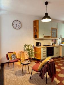 a living room with a kitchen and a clock on the wall at Residenza Renata in Onno