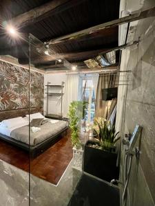 a room with a bed and some plants in it at Plebiscito Suite Apartment in Naples