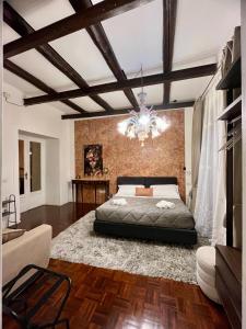 a bedroom with a large bed and a chandelier at Plebiscito Suite Apartment in Naples