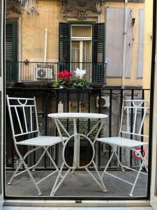 two chairs and a table in front of a balcony at Plebiscito Suite Apartment in Naples