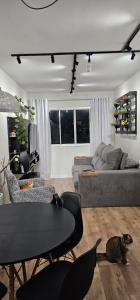 a living room with a couch and a table at Quarto em apartamento compartilhado no Jabaquara para mulheres e casal in Sao Paulo +2 photos