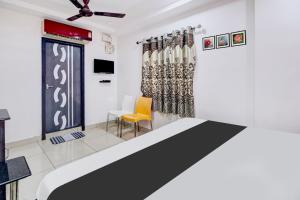 a room with a bed and a table and chairs at Hotel O Rajadhani in Guntūr
