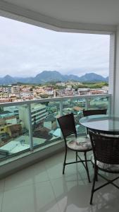 a room with a table and chairs and a large window at Vista para as Montanhas in Guarapari +7 photos