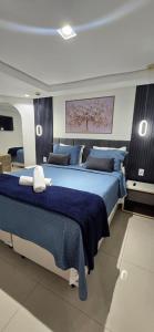 a large bedroom with two beds with blue sheets at Marinas Flat 420 in João Pessoa