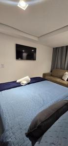 a bedroom with a large bed and a flat screen tv at Marinas Flat 420 in João Pessoa