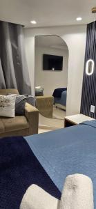a bedroom with a bed and a couch and a mirror at Marinas Flat 420 in João Pessoa