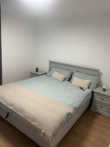 a bed in a bedroom with a white wall at PremiumSuites in Giurgiu