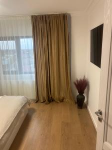a bedroom with a bed and a large window at PremiumSuites in Giurgiu +3 photos