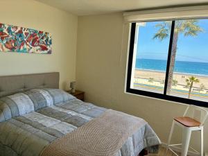 Departamento Borde Mar في كوكيمبو: غرفة نوم مع سرير وإطلالة على الشاطئ