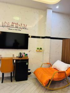 Bảo Ngọc Hotel في Cao Lãnh: غرفة بها سرير ومكتب وتلفزيون