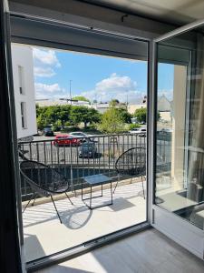 balcón con sillas y vistas a un aparcamiento en Charmant T3 à Angers - parking gratuit, en Angers