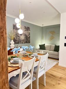 une salle à manger avec une table et des chaises blanches dans l'établissement Fewo Sand 10 - groß, à Bamberg