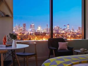 Una habitación con vista al horizonte de la ciudad desde una ventana. en Art Series - The Larwill Studio, en Melbourne