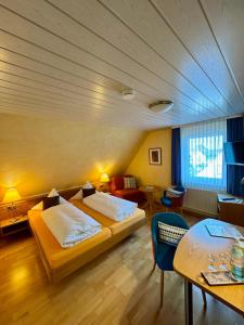 a hotel room with two beds and a table at Hotel-Restaurant Gasthof Adler in Neuenburg am Rhein