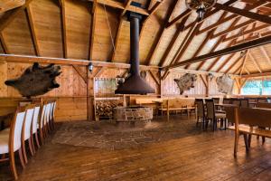 a dining room with a fireplace in a wooden barn at Hotel Muszyna in Muszyna