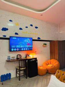 Bảo Ngọc Hotel في Cao Lãnh: غرفة بها تلفزيون على الحائط مع سحب زرقاء +16 صورة