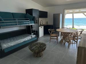 Habitación con litera, mesa y cocina. en Maison confortable avec vue sur la mer à Le Diamant, 48 m², en Le Diamant 7 fotos más