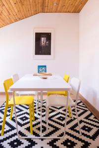 a dining room with a white table and yellow chairs at Our Friends Apartment in Lisbon