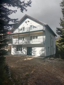 ein großes weißes Gebäude mit einem Balkon darauf in der Unterkunft La Costel Rânca in Baia de Fier