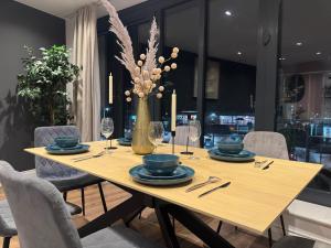 una mesa de comedor con un jarrón con flores. en Lux 2 Bedroom Flat Central Brentwood slp 8 Guests, en Brentwood