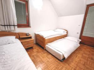 1 dormitorio con 3 camas y suelo de madera en Apartma Roglina, en Zreče 6 fotos más