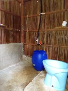 a bathroom with a toilet and a blue barrel at Wobbegong Raja Ampat in Yennanas Besir