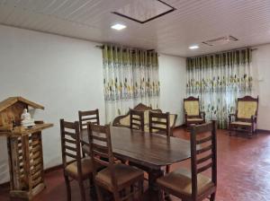 a dining room with a wooden table and chairs at White Rose Holiday Resort in Anuradhapura +18 photos