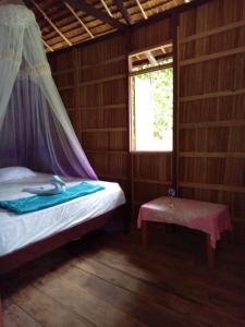a small bedroom with a bed and a window at Wobbegong Raja Ampat in Yennanas Besir