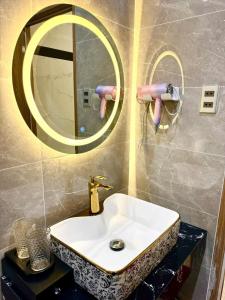 Bảo Ngọc Hotel في Cao Lãnh: حمام مع حوض ومرآة مستديرة