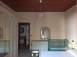 a bedroom with a bed and a mirror and a crib at Casa Vacanze AnnaLù IUN R5074 in Orosei