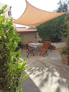a patio with a table and chairs under a canopy at Casa Vacanze AnnaLù IUN R5074 in Orosei +12 photos
