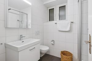a white bathroom with a sink and a toilet at Luxury 1BR in the city center - Color 5 in Zürich +14 photos