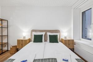 a white bedroom with a large bed with green pillows at Luxury 1BR in the city center - Color 5 in Zürich