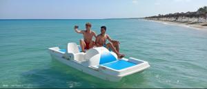 two men sitting on a boat in the water at Wonder Land Hotel in Ras Sedr +9 photos